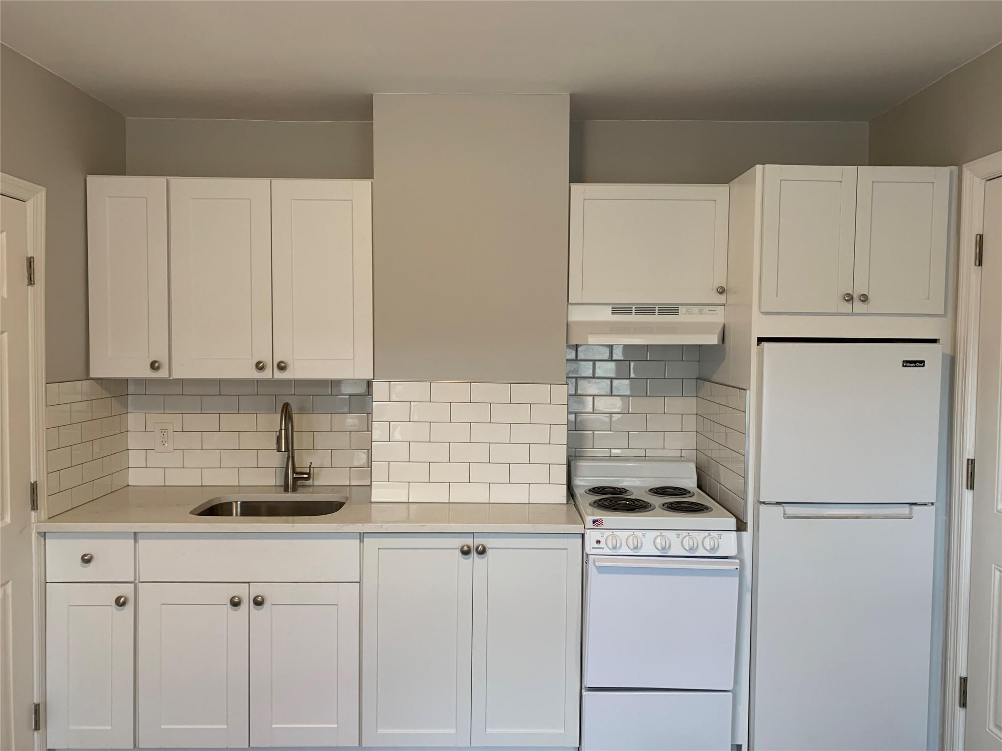 a kitchen with appliances a sink and cabinets