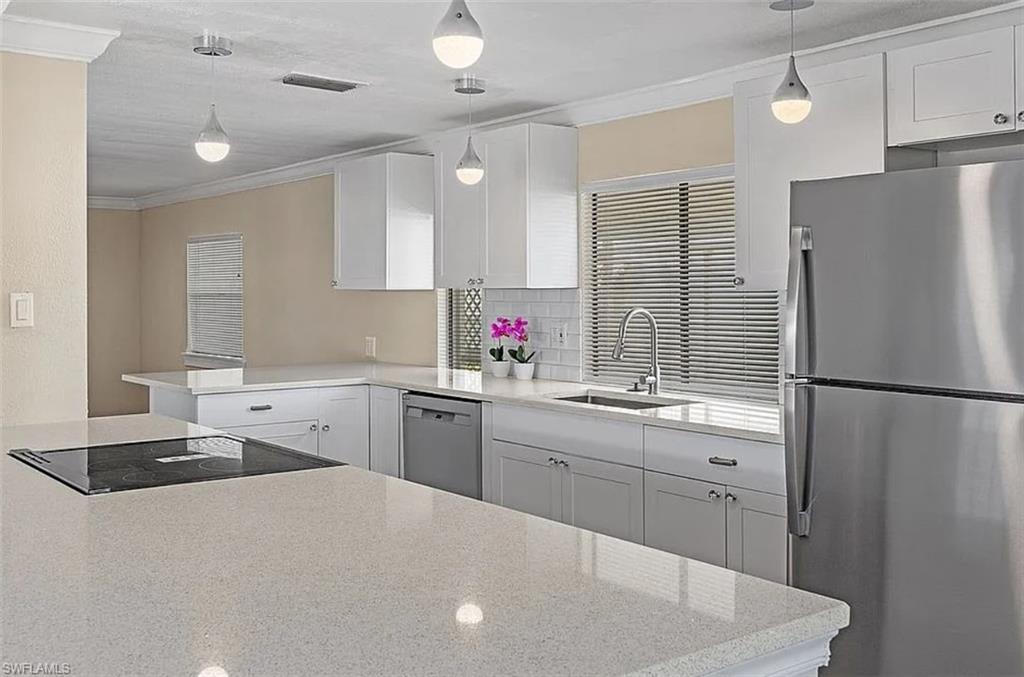 a kitchen with stainless steel appliances a refrigerator sink and white cabinets