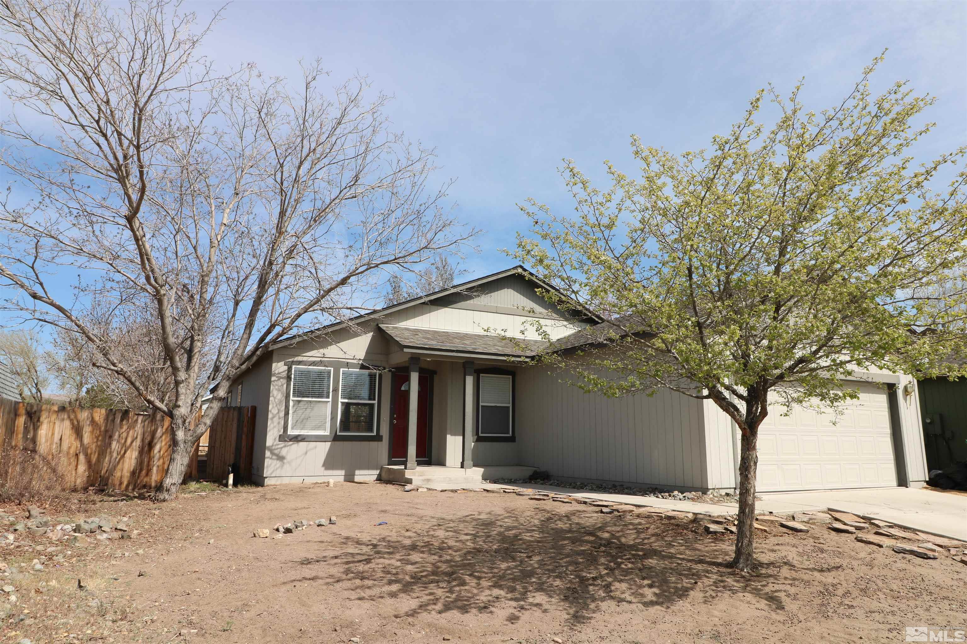 a front view of a house with a tree