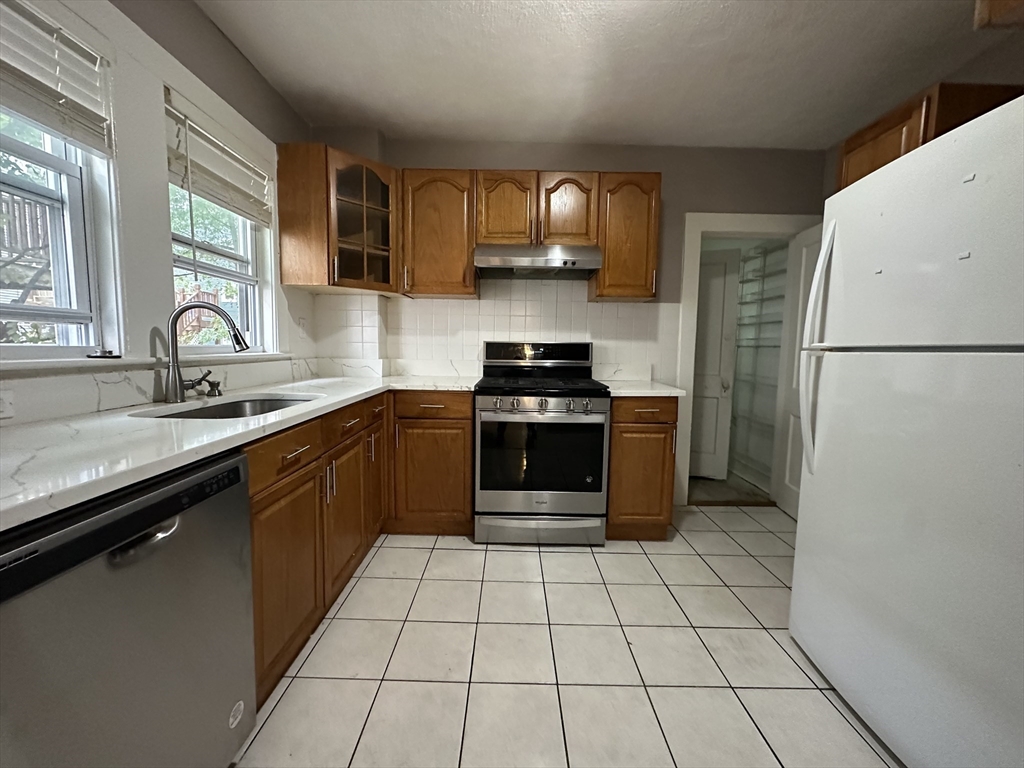 a kitchen with a sink a stove and a refrigerator