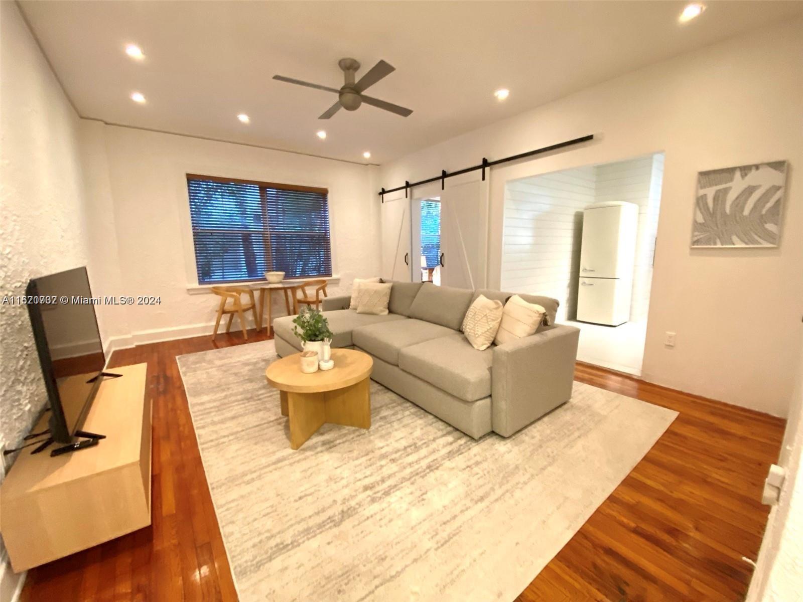 a living room with furniture and a wooden floor