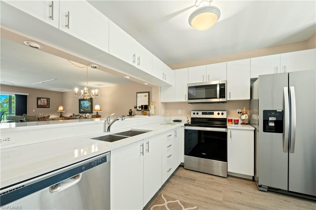 a kitchen with a sink stainless steel appliances and white cabinets