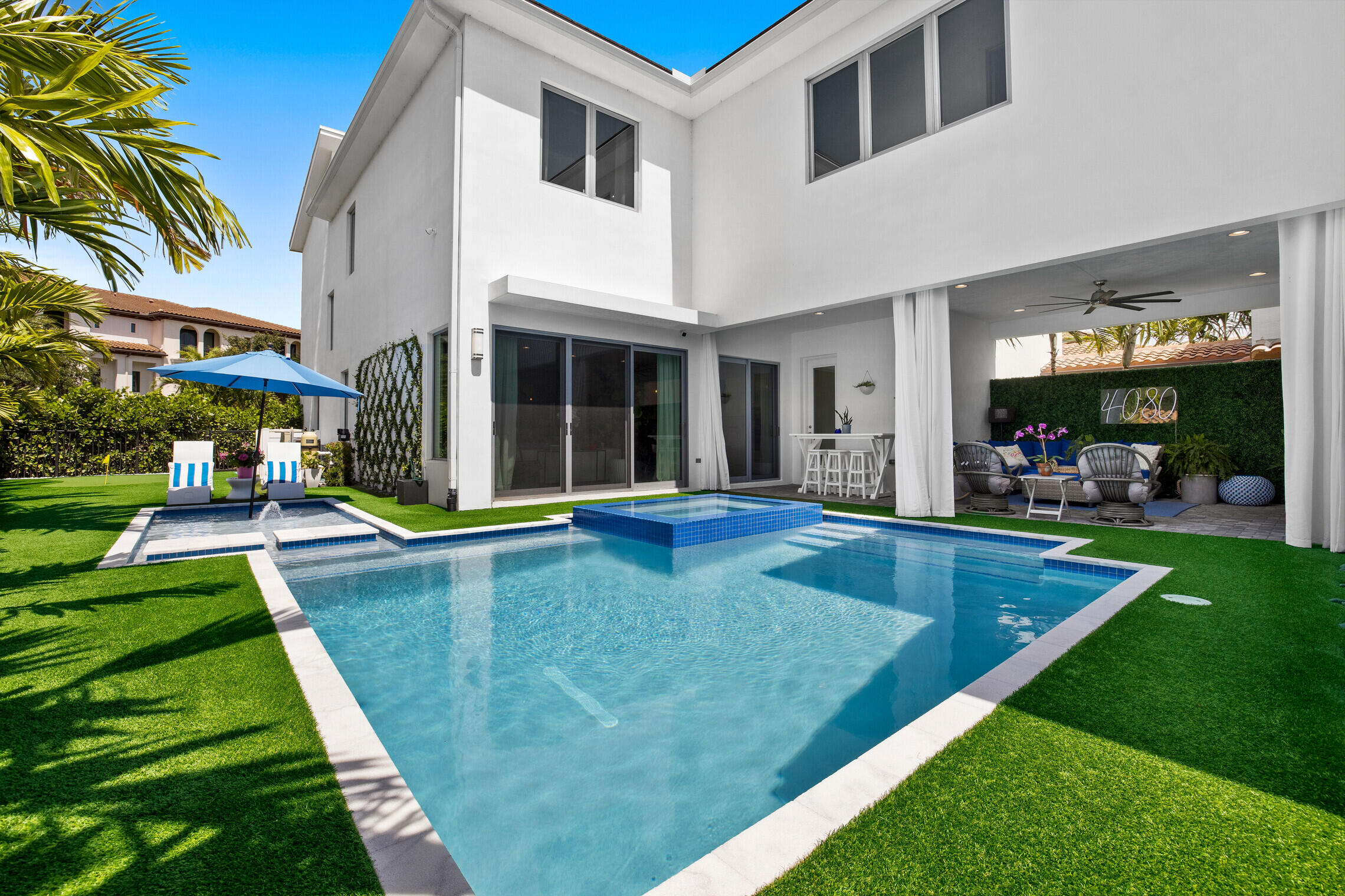 a view of a house with swimming pool and sitting area