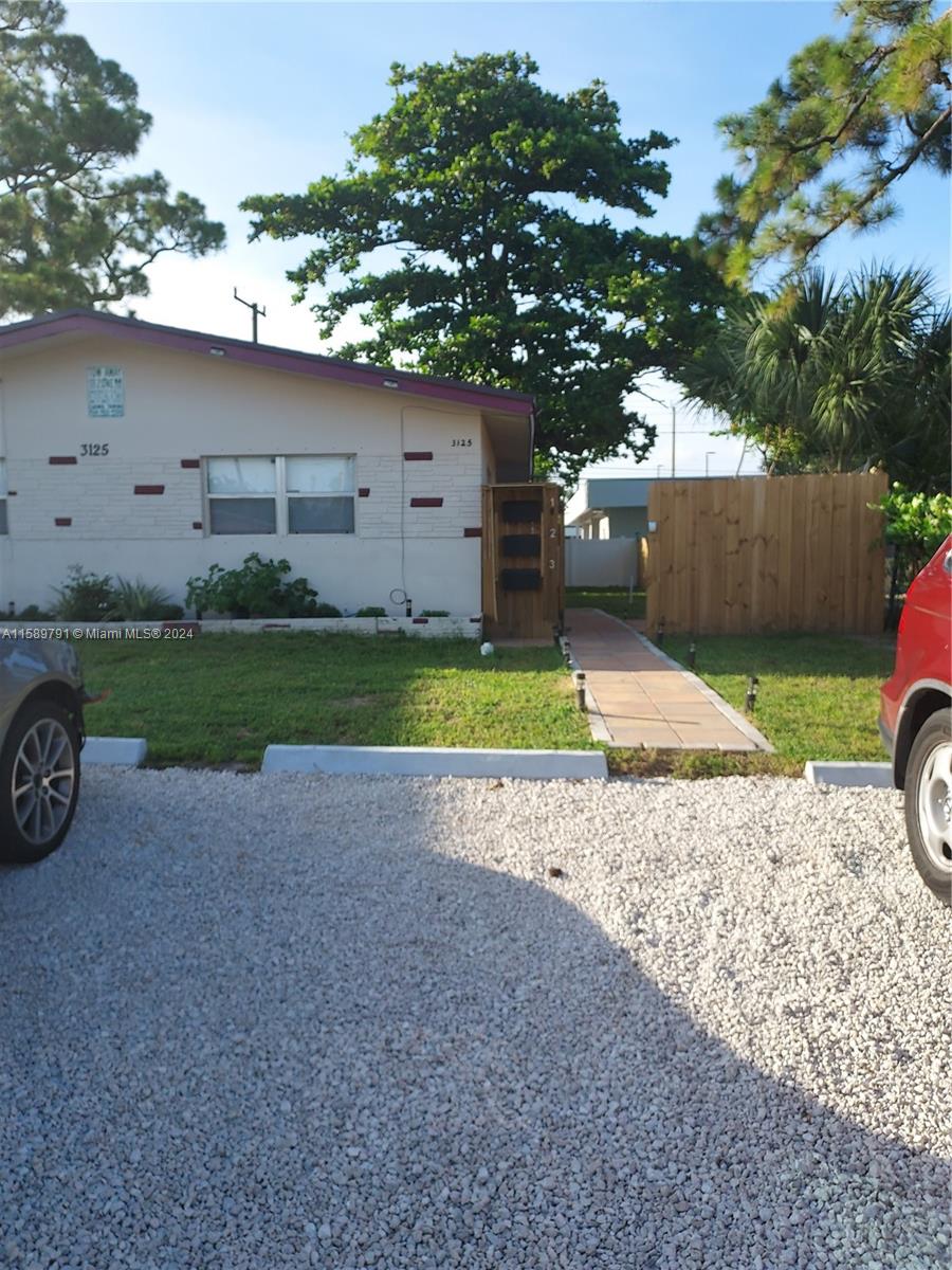 a view of a house with backyard and a car parked in it