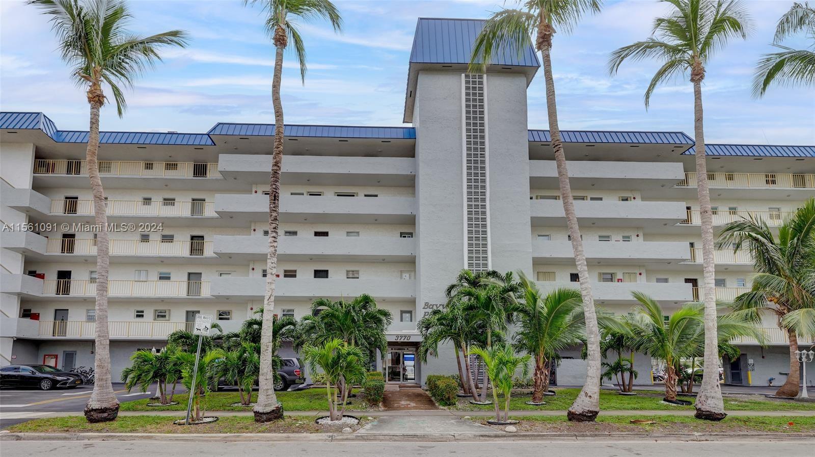 a front view of a building with palm trees