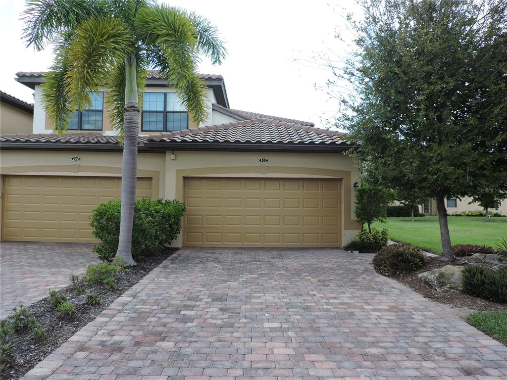 a front view of a house with a garden and garage