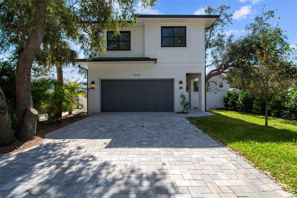 a front view of a house with a yard and a garage