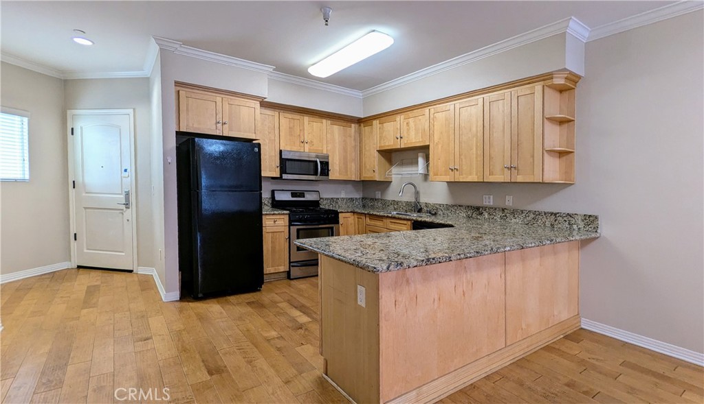 a kitchen with stainless steel appliances granite countertop a refrigerator a stove a sink and a granite counter tops