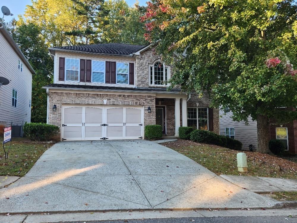 a front view of a house with a yard and a garage