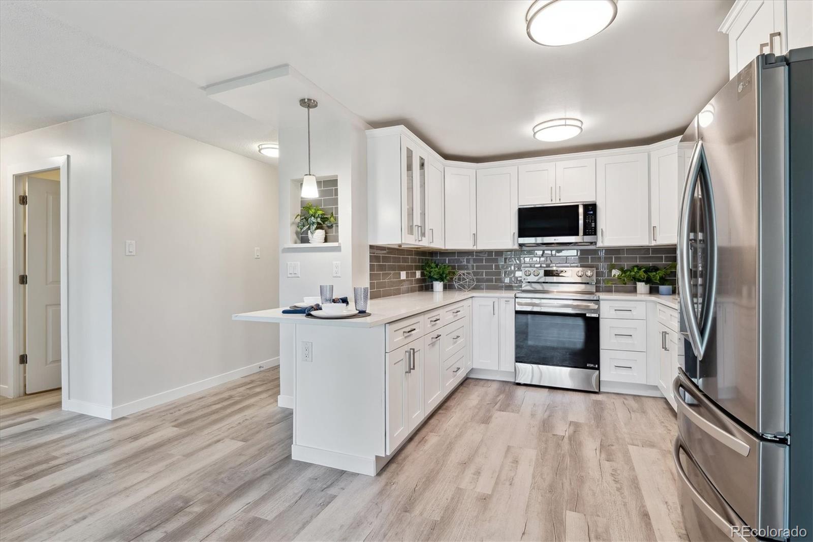 a kitchen with white cabinets stainless steel appliances and a refrigerator