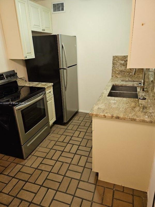 a kitchen with a stove a refrigerator and a sink