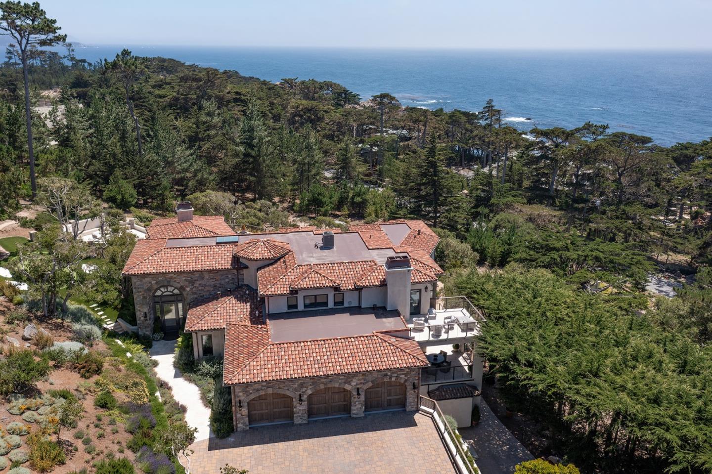 an aerial view of a house with a garden and lake view