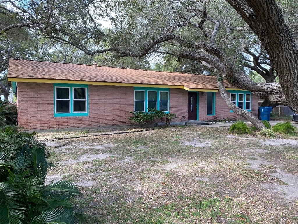 a front view of house with yard and trees around