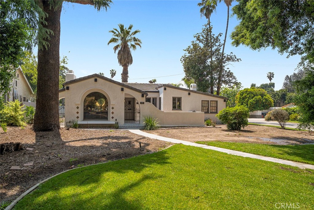 a view of a house with backyard and a tree