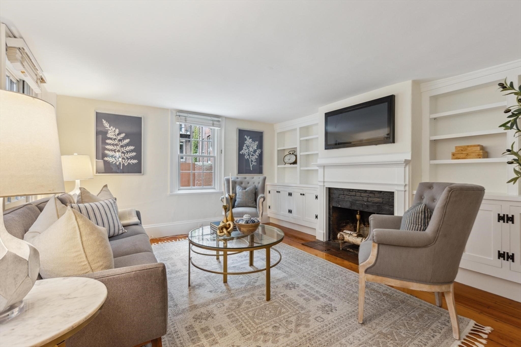 a living room with furniture a flat screen tv and a fireplace