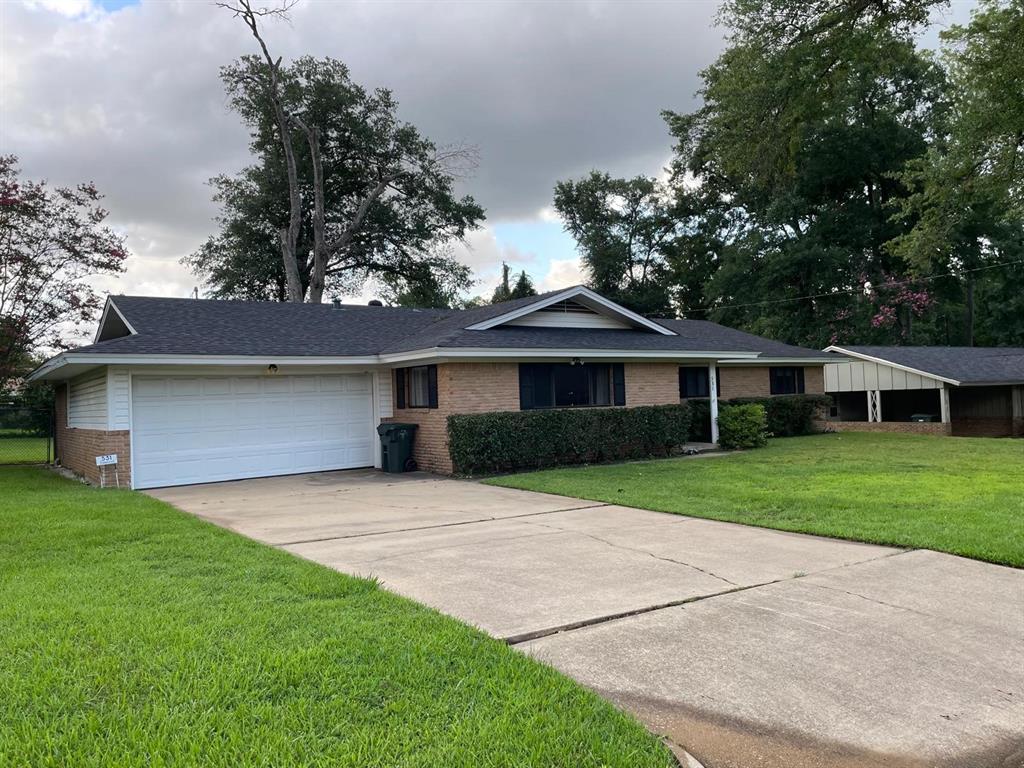 a front view of a house with a yard and trees