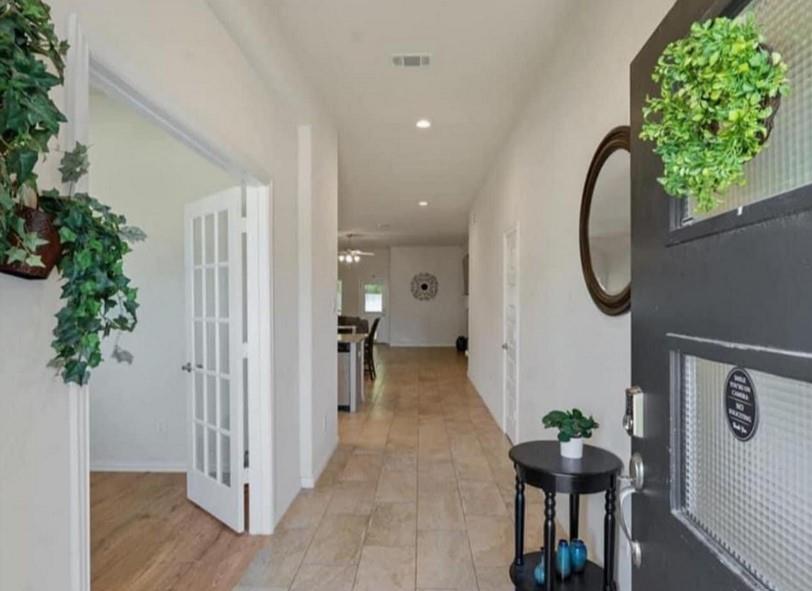 an entryway with wooden floor and a bench