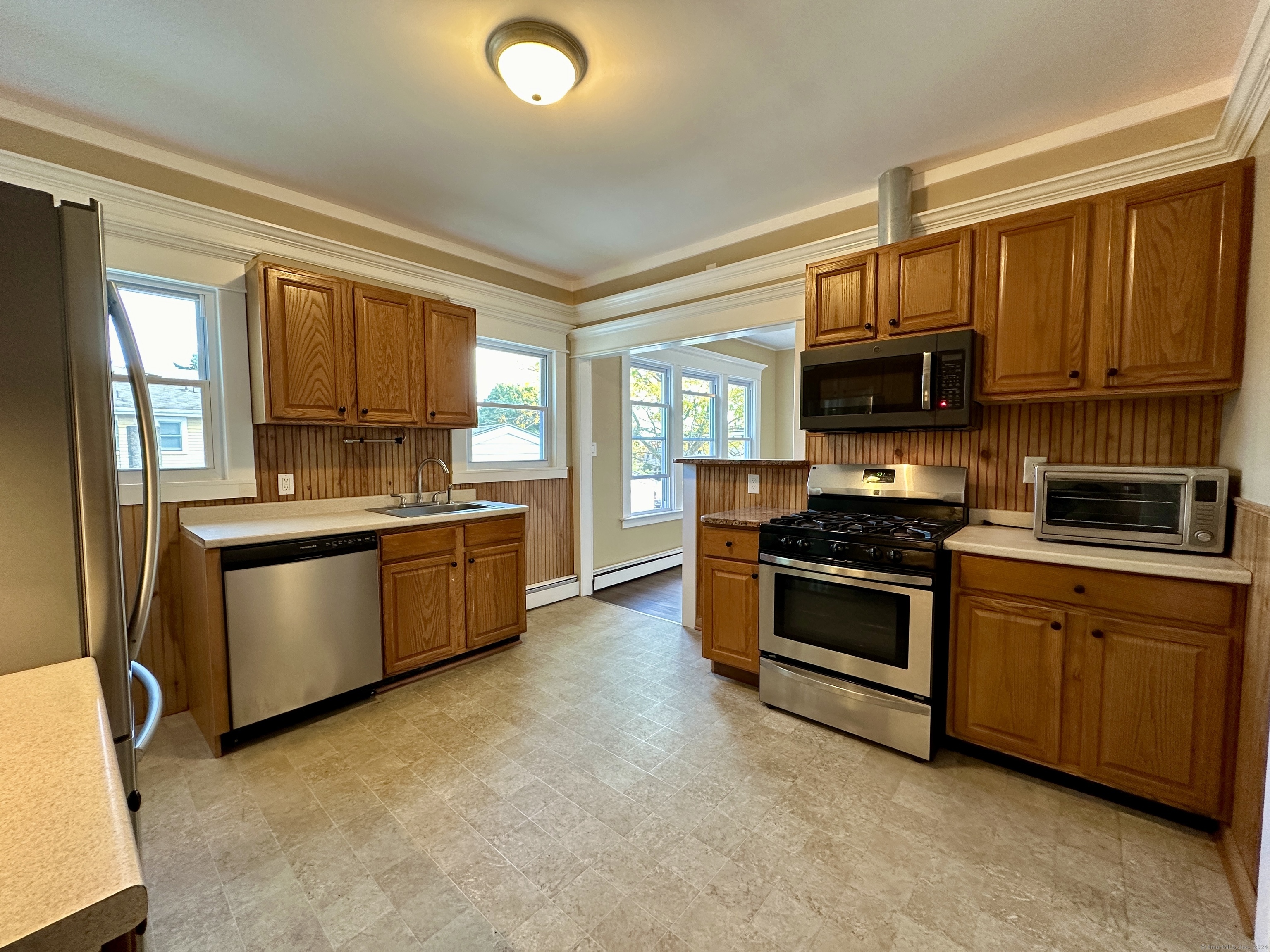 a kitchen with stainless steel appliances granite countertop a stove a sink and a refrigerator