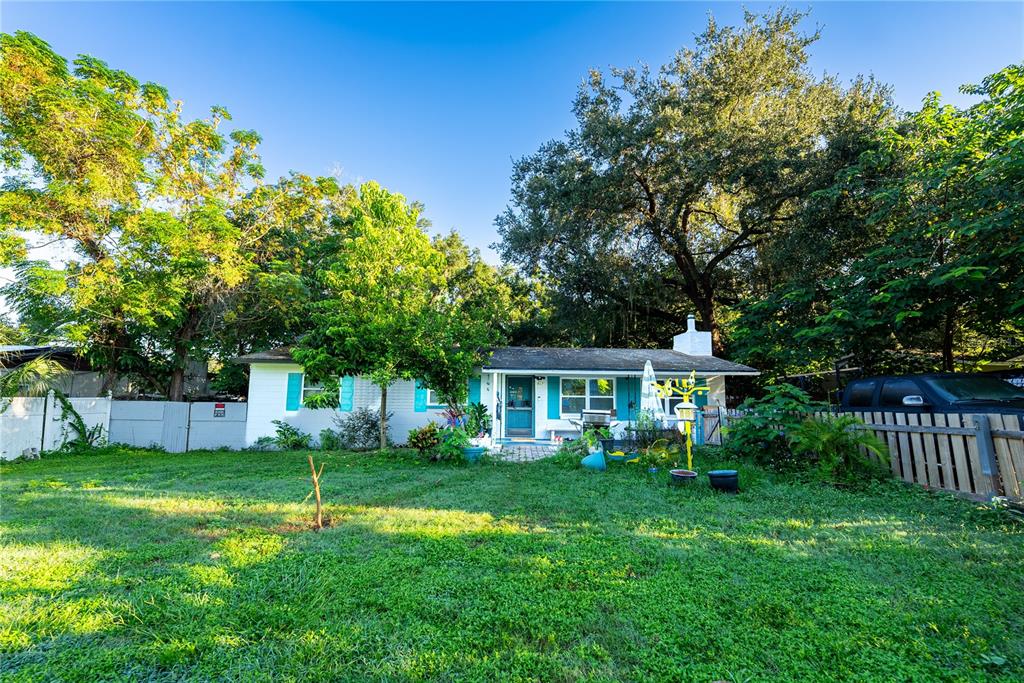 a view of house with a backyard and a patio