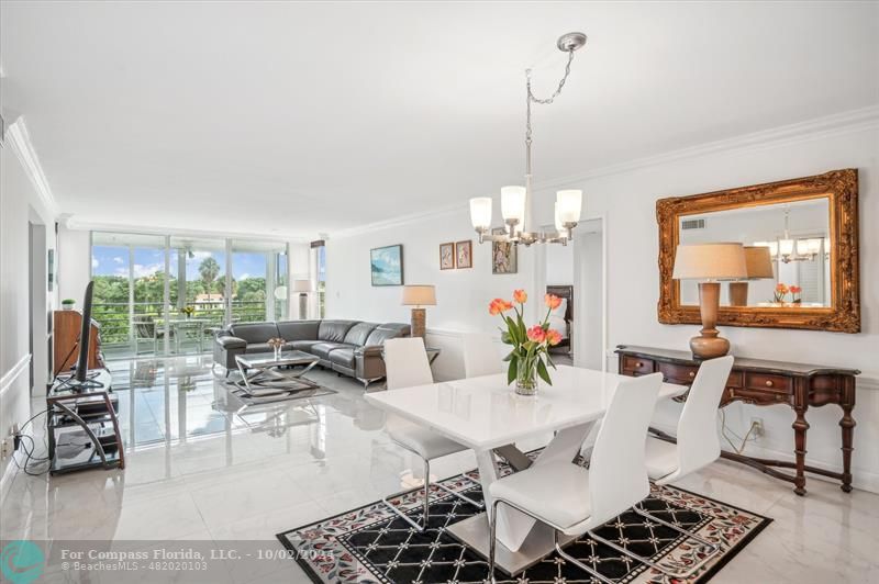 a living room with furniture a chandelier and a dining table