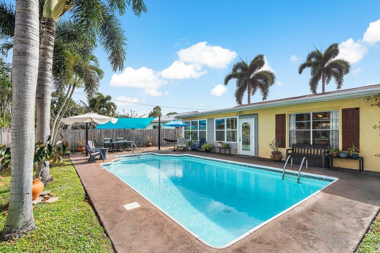 a view of a house with swimming pool and sitting area