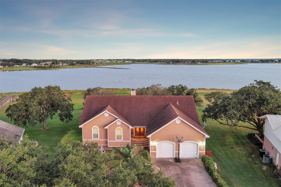 an aerial view of a house with a garden and lake view