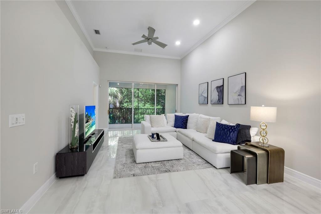 a living room with furniture a flat screen tv and a large window