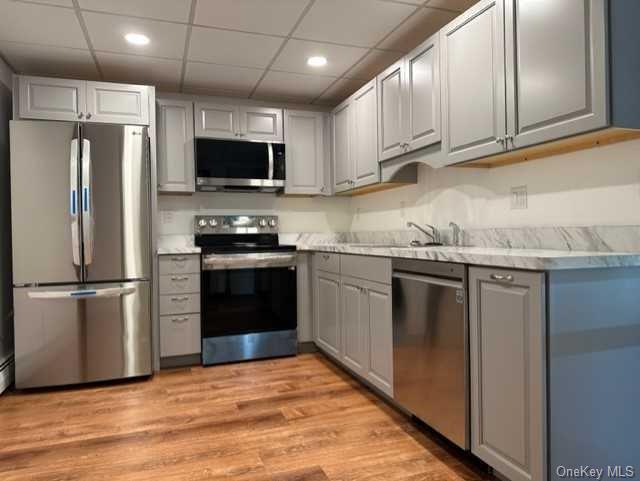 a kitchen with stainless steel appliances granite countertop a refrigerator stove a sink and a microwave