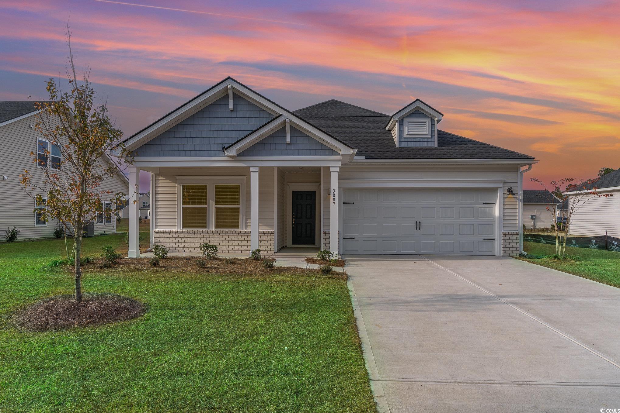 Craftsman house featuring a yard and a garage