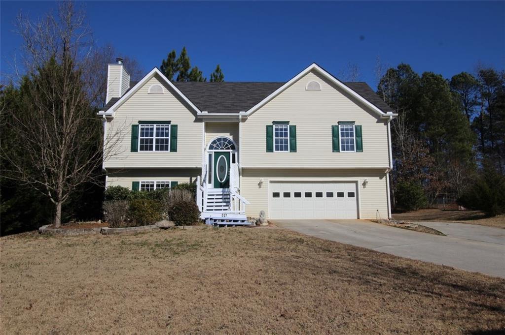 a view of a white house with a yard and garage