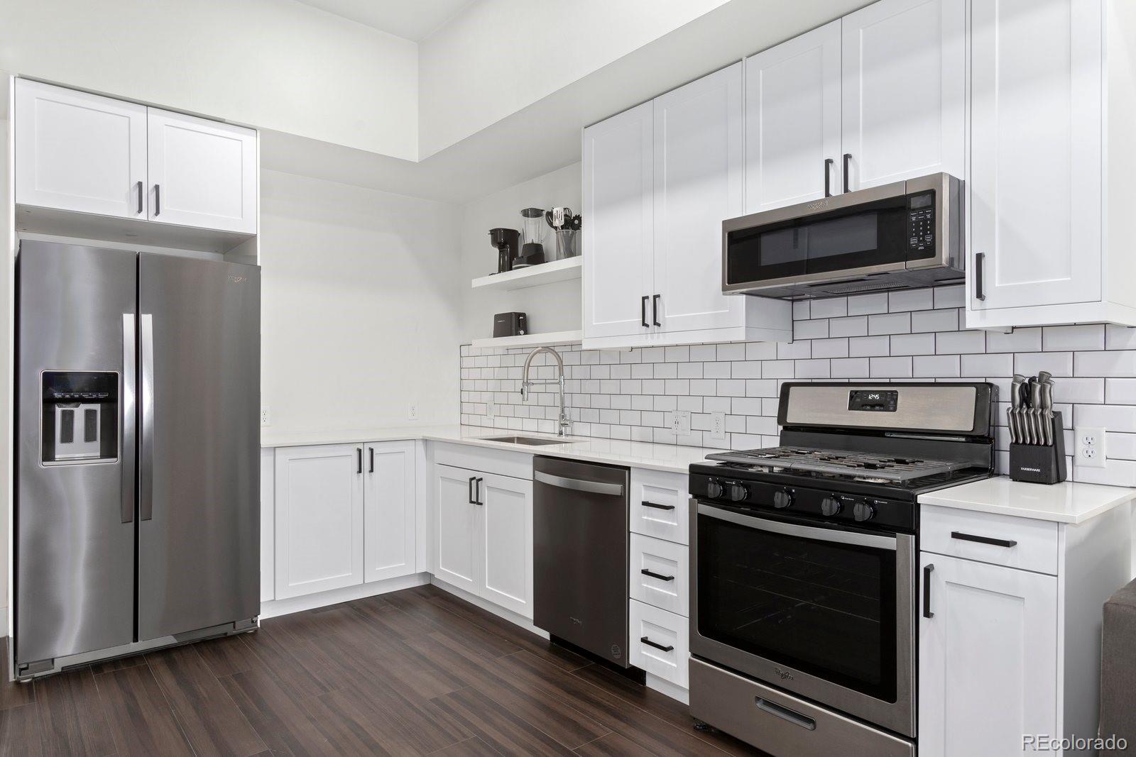 a kitchen with stainless steel appliances and white cabinets