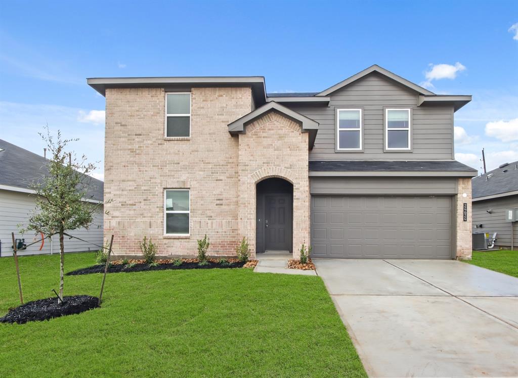 a front view of a house with a yard and garage