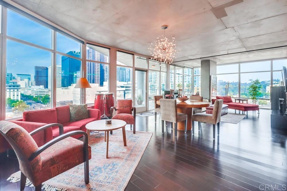 a living room with furniture a chandelier and a large window