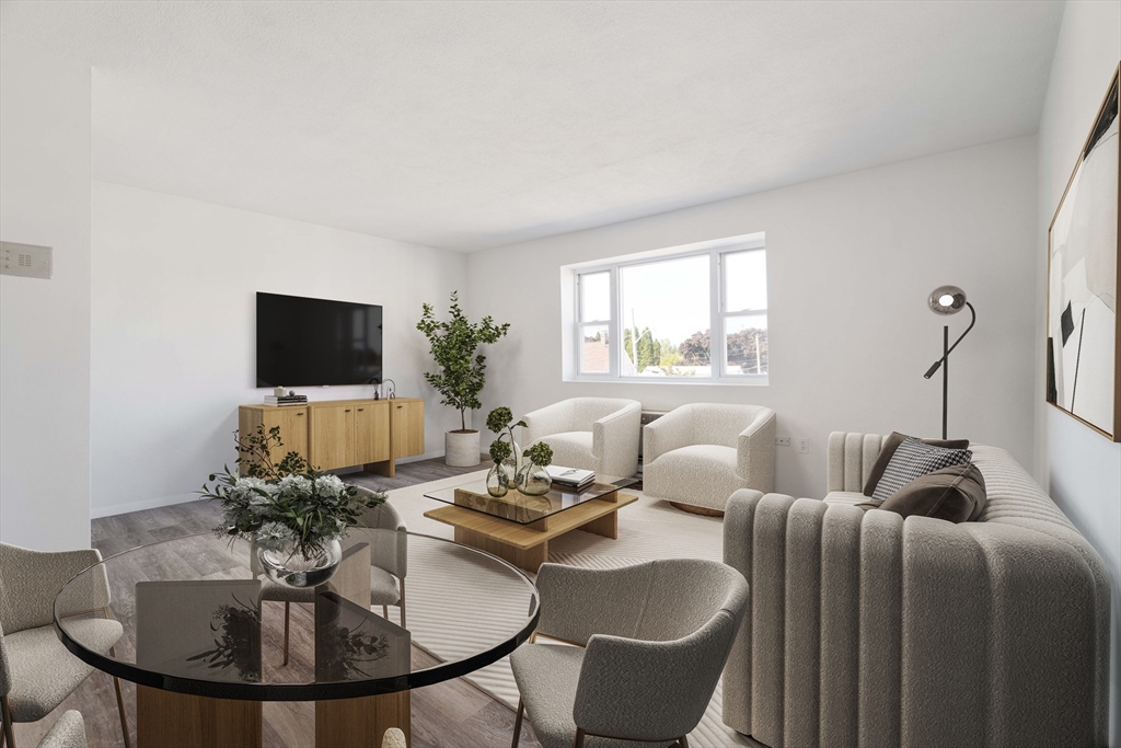 a living room with furniture a flat screen tv and a large window