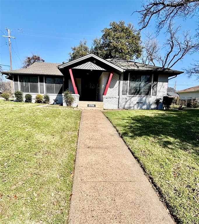 a front view of house with yard slide and large trees