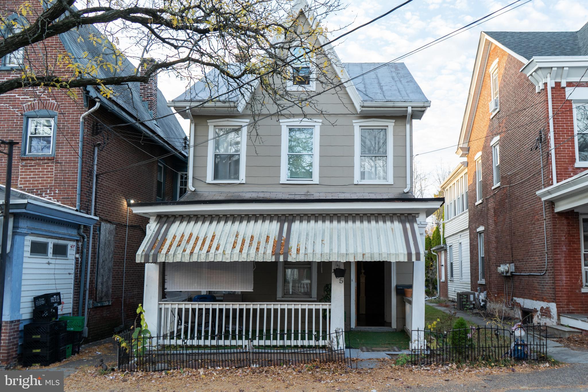 a view of a brick house with large windows and a small yard