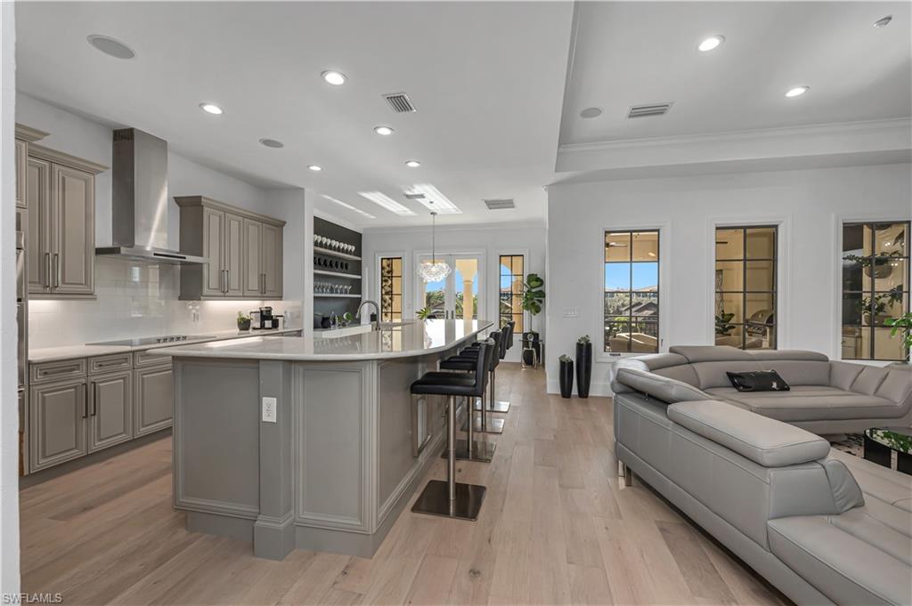 a living room with stainless steel appliances granite countertop furniture and a wooden floors