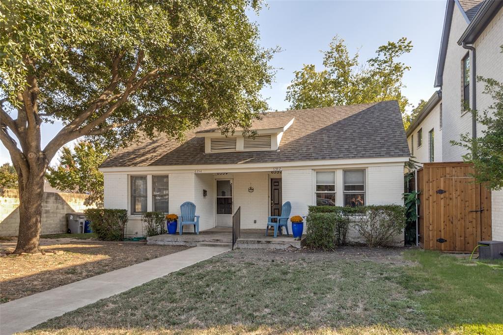 a view of a yard in front of a house with large tree