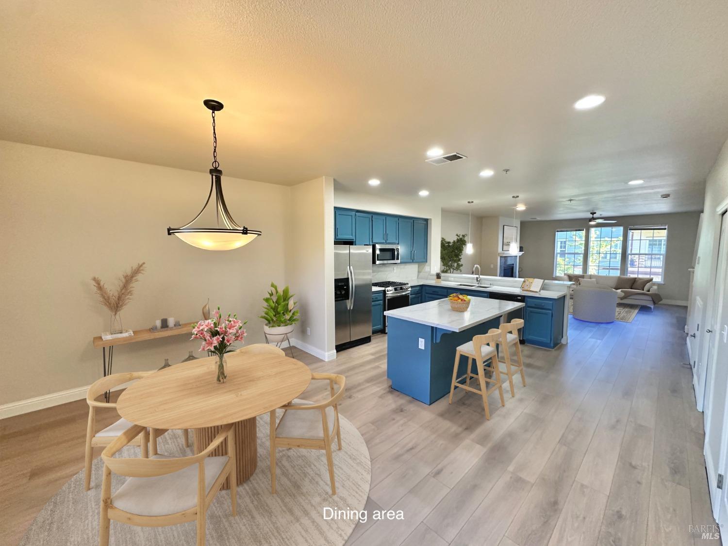 a view of a dining room and a livingroom with furniture wooden floor a chandelier