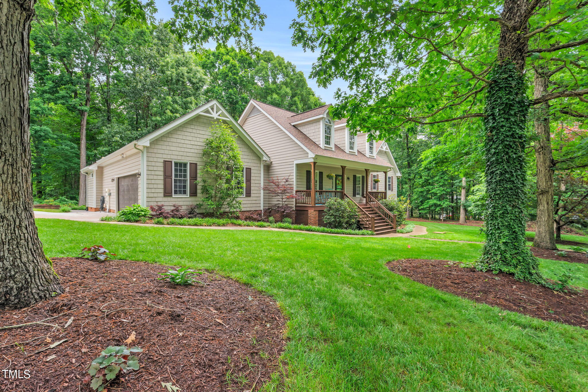 a front view of a house with a yard and green space