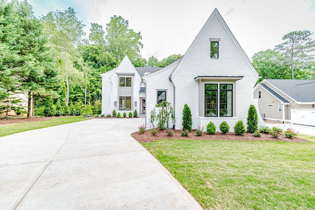 a front view of a house with a yard and potted plants