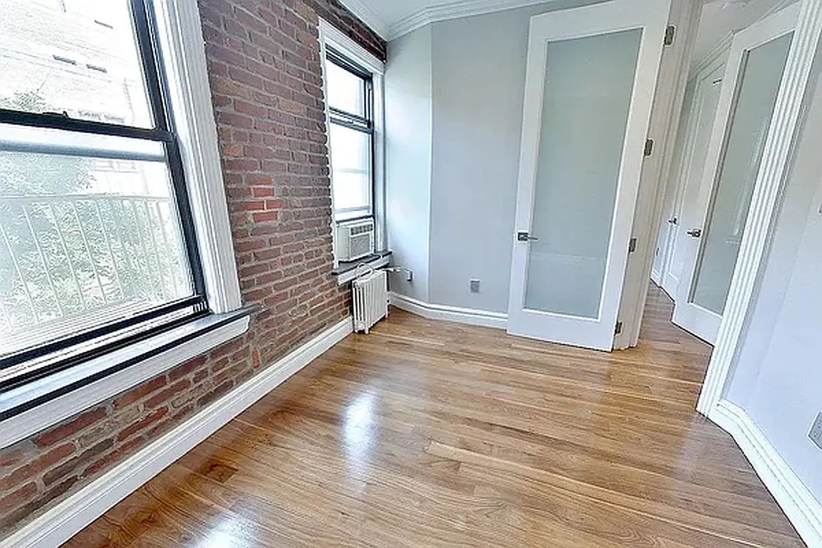 a view of a room with wooden floor and windows