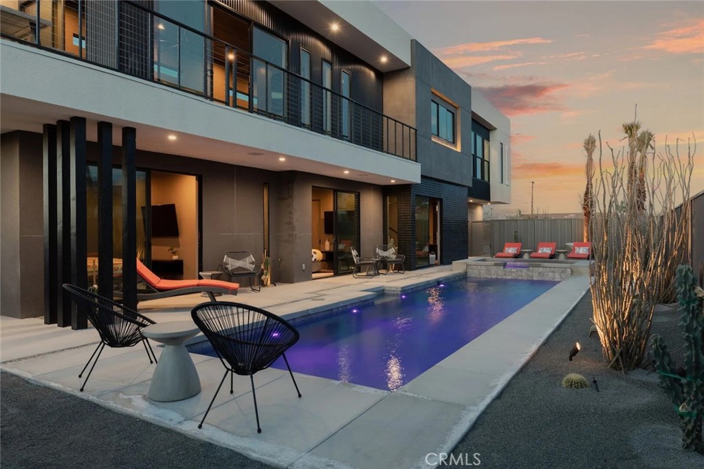 a view of a house with swimming pool and sitting area