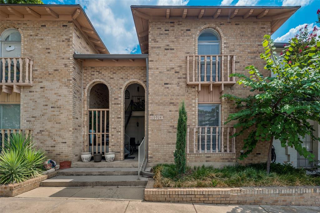 front view of a brick house with a small yard