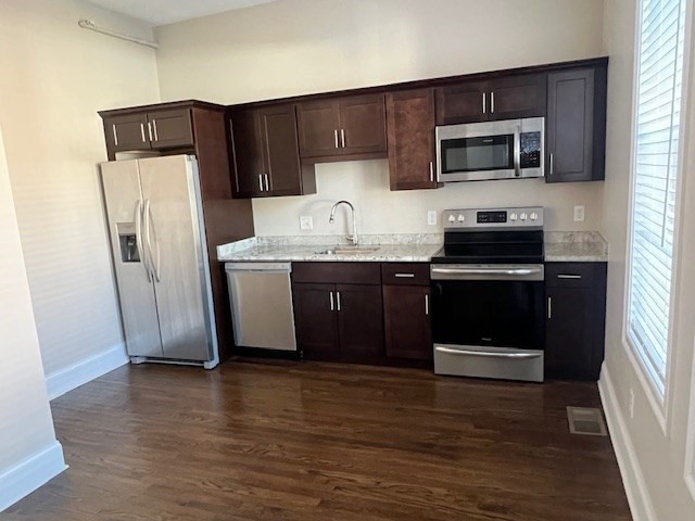 a kitchen with stainless steel appliances granite countertop a refrigerator and a stove top oven