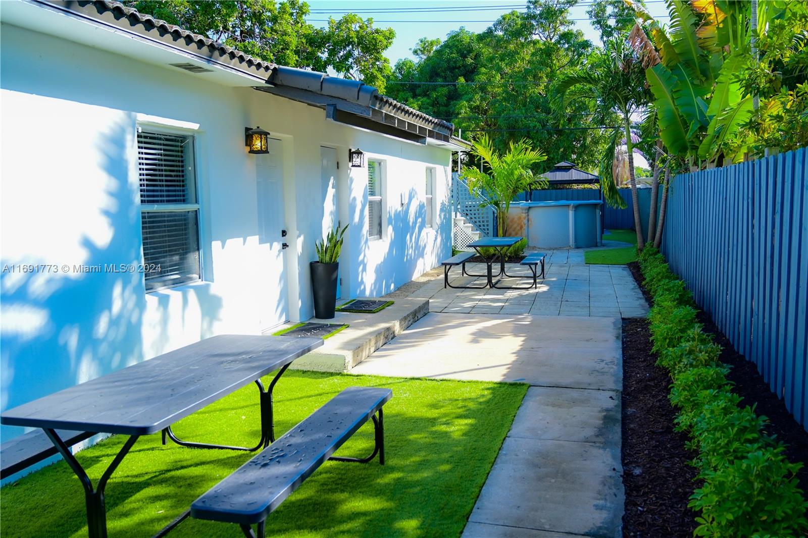 a view of a chair and table in backyard of the house