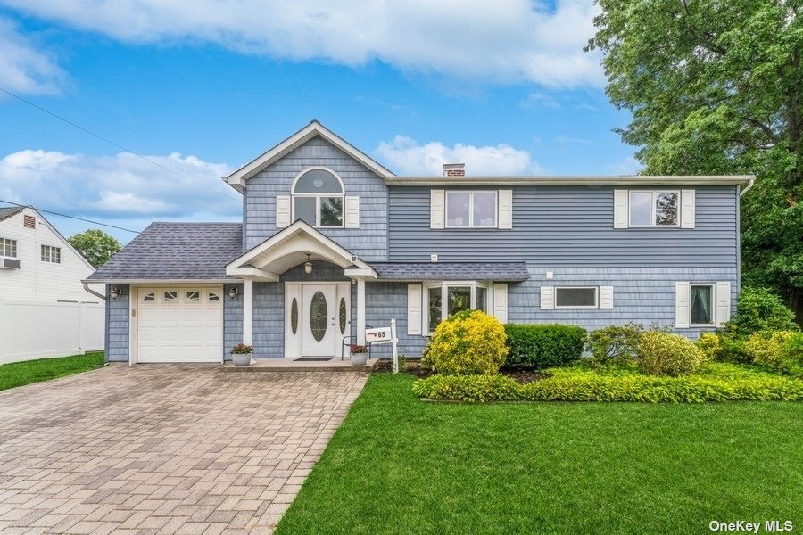 a front view of a house with a yard and trees