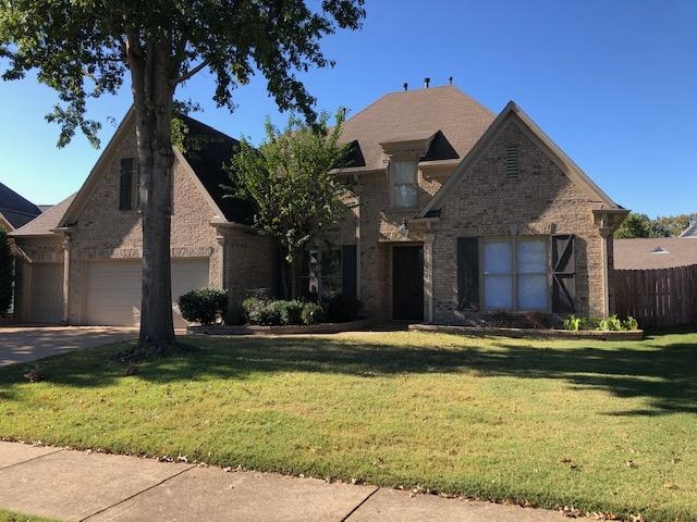 View of front of home with a garage and a front yard