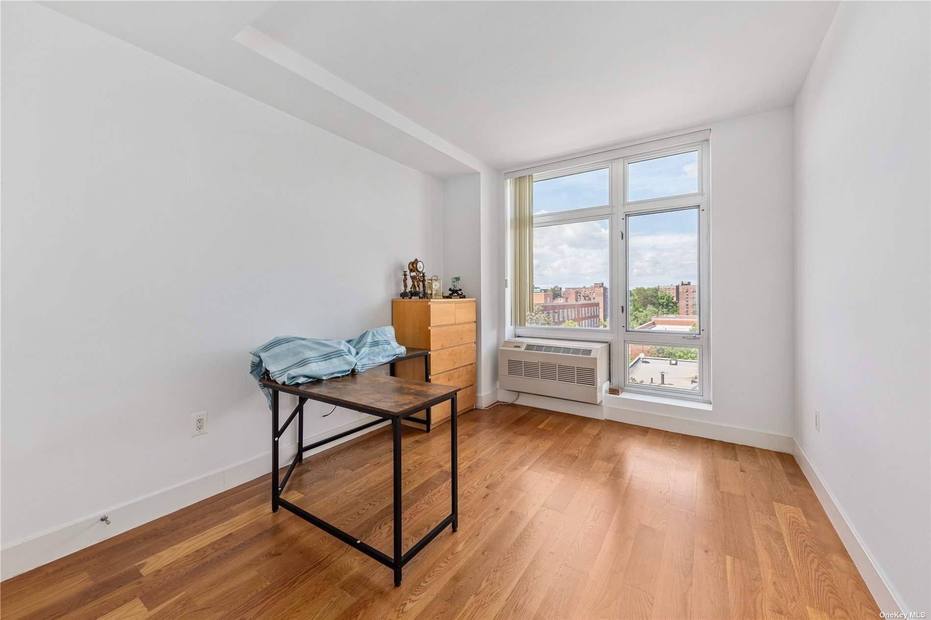 a view of a workspace with furniture and a window