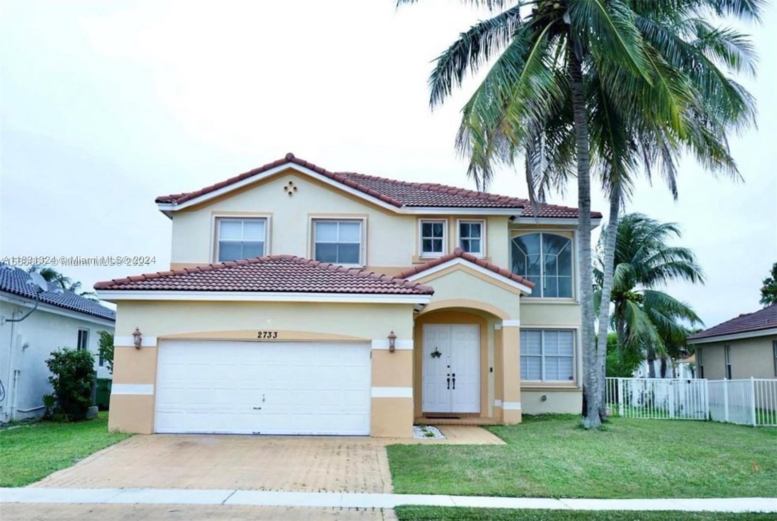 a front view of a house with a garden and plants